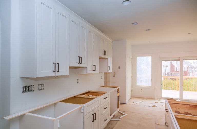 Newly installed white kitchen cabinets and countertops in a home improvement project