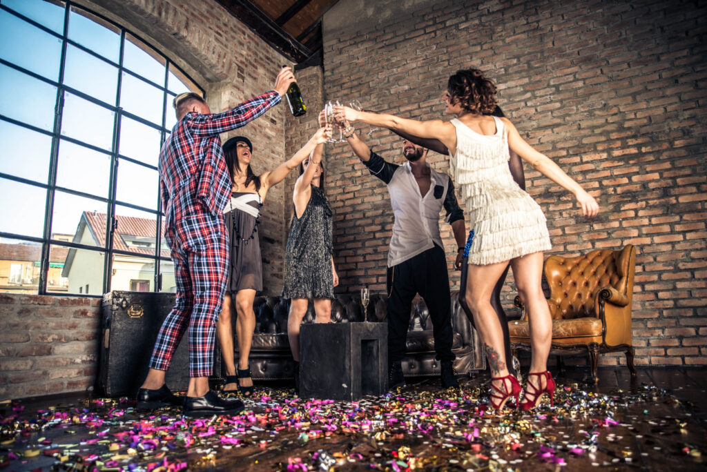 Friends celebrating a small party with champagne and confetti.