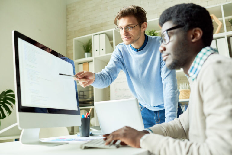 Software developers collaborating on computer code in web studio