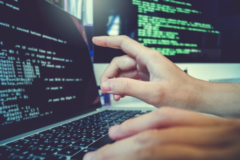 Programmer working on laptop illustrating career development and tech startup resources.
