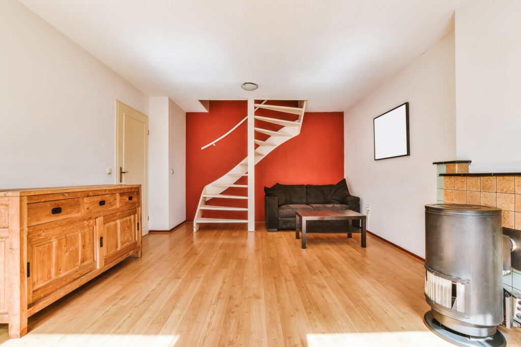 Modern interior design with red accent wall and spiral staircase, enhancing home value.