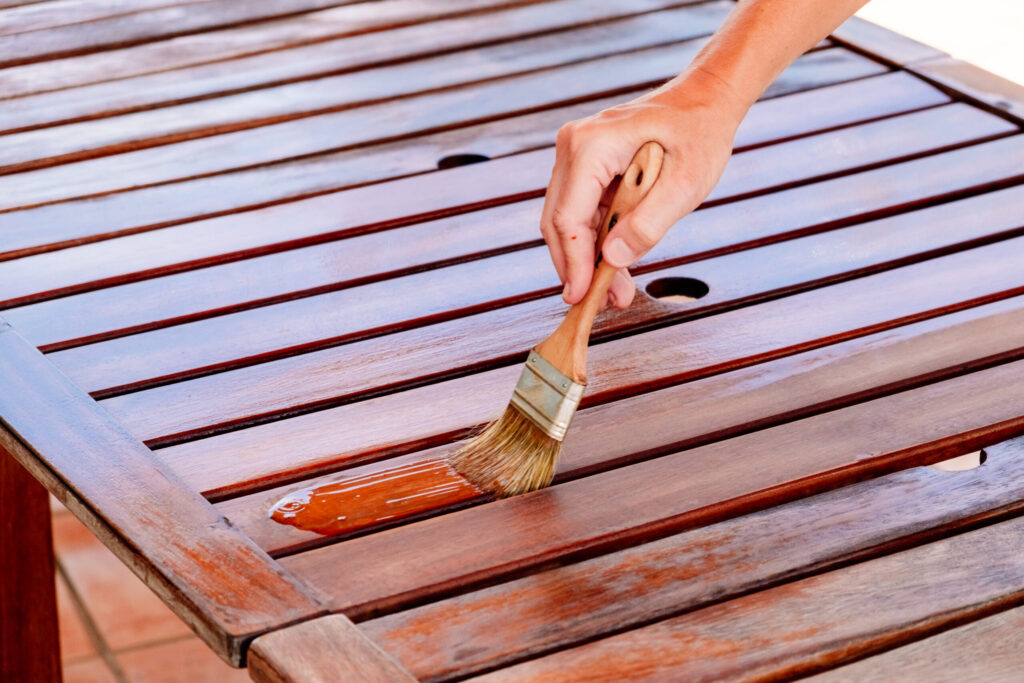 Applying teak oil to wooden table for home maintenance
