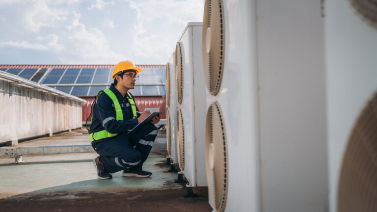 HVAC technician inspecting air conditioning units for home maintenance and comfort