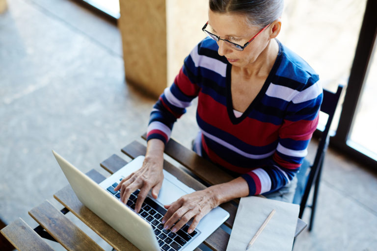a person sitting in a chair using a laptop