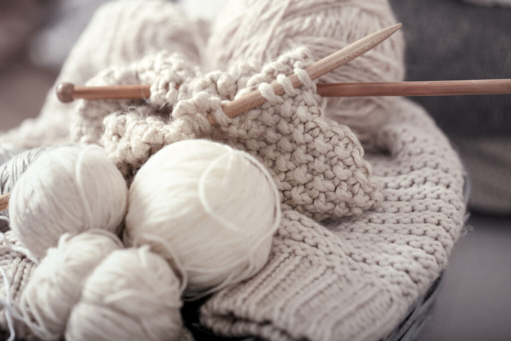 Knitting wool and needles illustrating thermal regulation properties of wool