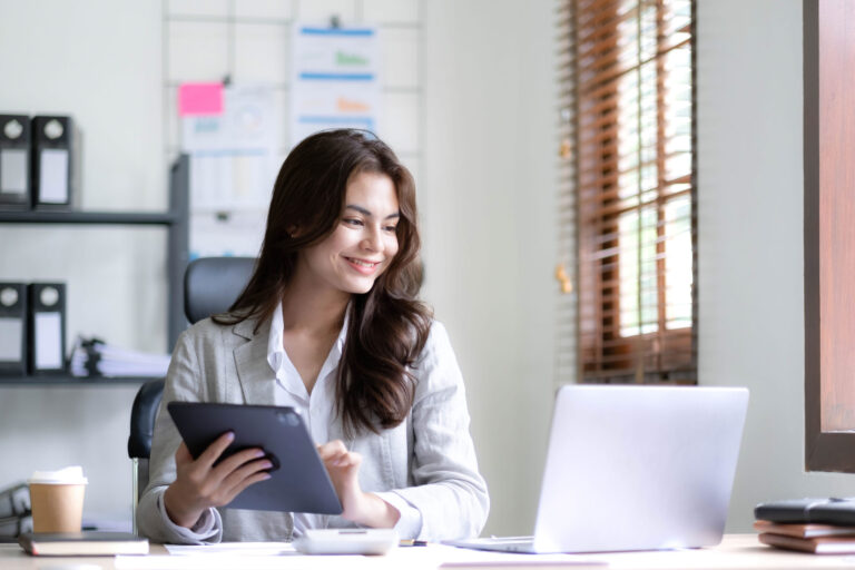 Asian business woman using laptop and calculator for technology tasks